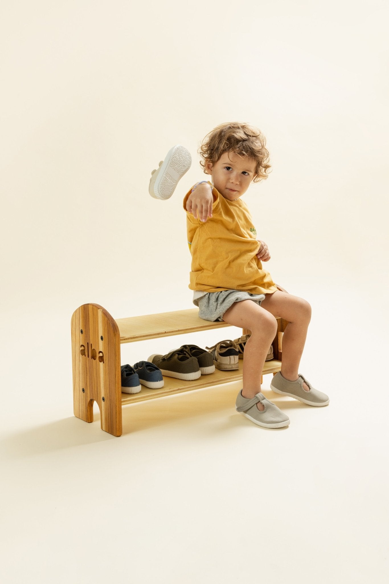 Zapatero y banca Montessori de madera Happy Feet de Minimaall Petit, vista en ángulo con niño interactuando con zapato